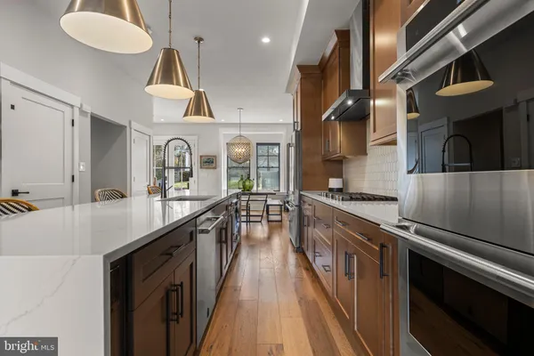 a kitchen with stainless steel appliances a sink a stove and a wooden floors