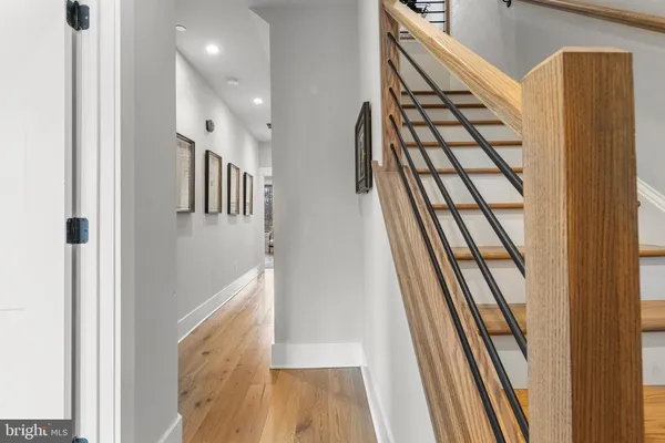 a view of a hallway with wooden floor and staircase