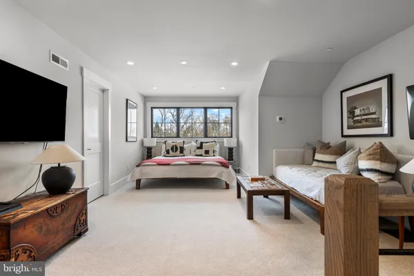 a bedroom with furniture and a flat screen tv