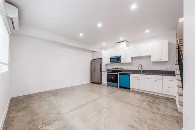 a large kitchen with stainless steel appliances granite countertop a stove a sink and a refrigerator