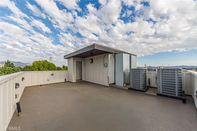 a view of a house with barbeque and wooden fence