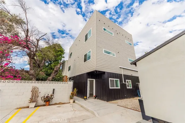a front view of a house with a tree