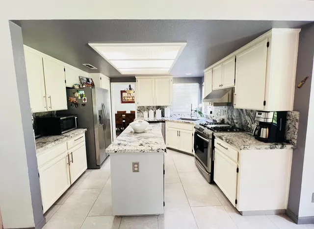 a kitchen with white cabinets and white appliances