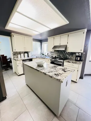 a kitchen with stainless steel appliances granite countertop a sink stove and cabinets