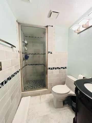 a bathroom with a toilet and a shower