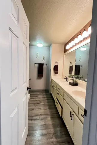 a large white kitchen with a sink and dishwasher a stove with wooden floor