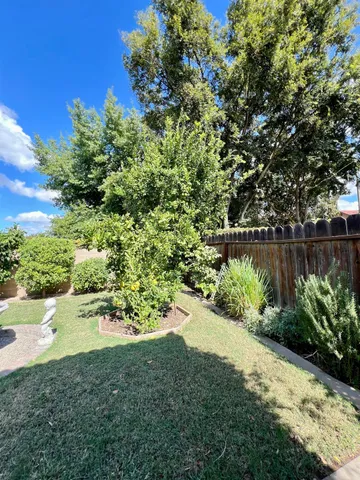 a patio with table and chairs and potted plants
