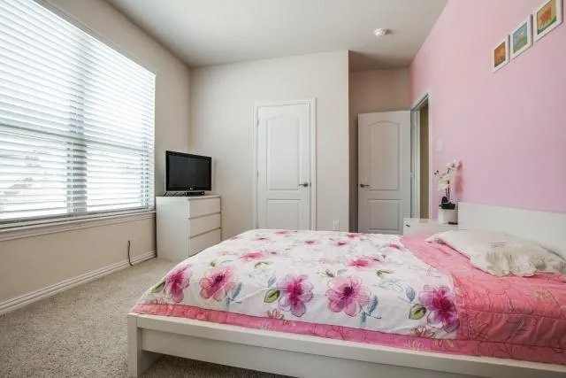 a bedroom with a bed and a flat screen tv