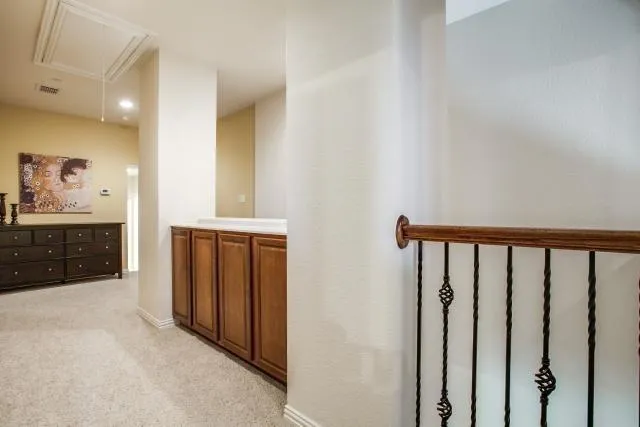 a view of a hallway with bathroom and mirror