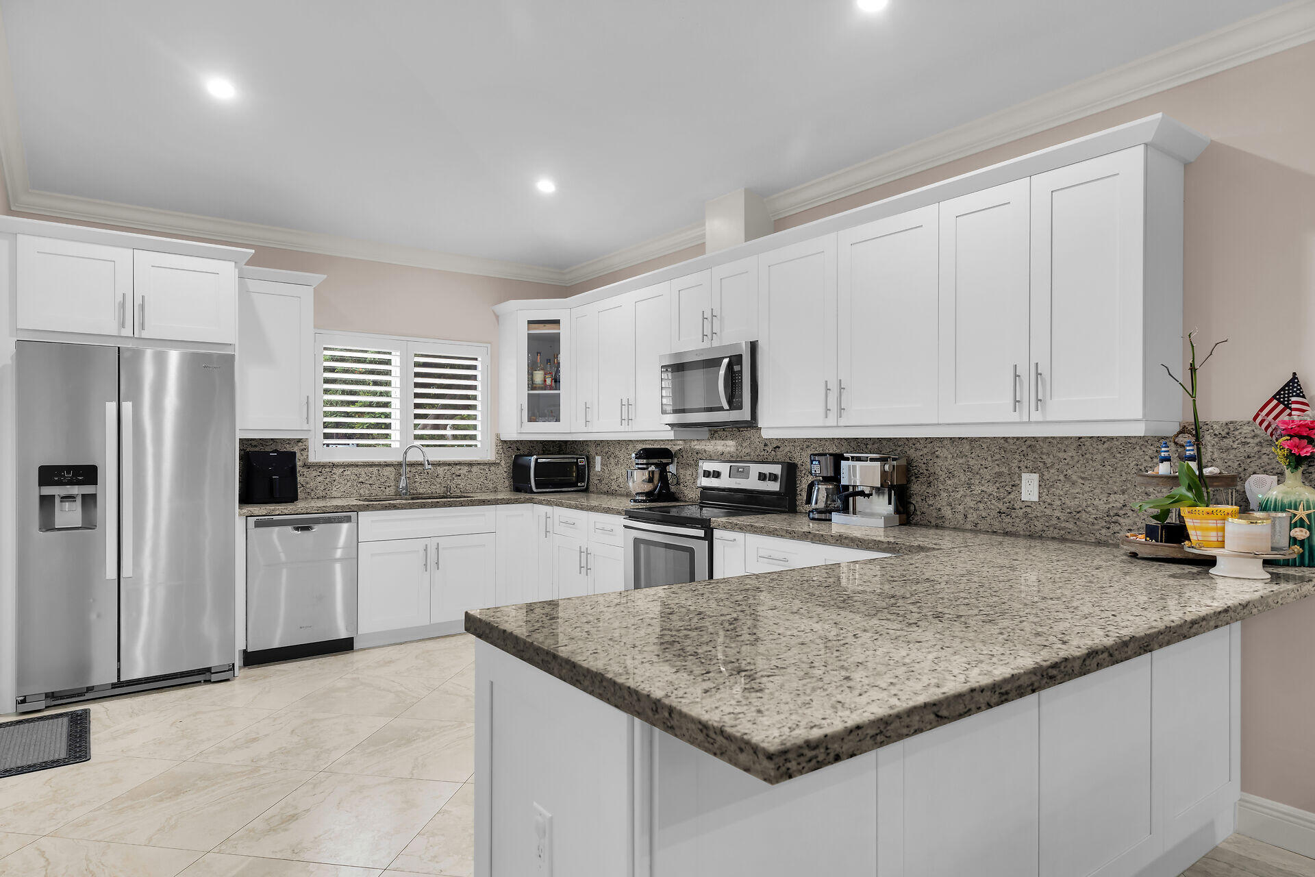 16 Jewfish Avenue Key Largo, FL 33037 - Photo 14 of 69 a kitchen with stainless steel appliances granite countertop a sink dishwasher a refrigerator oven and white cabinets with wooden floor