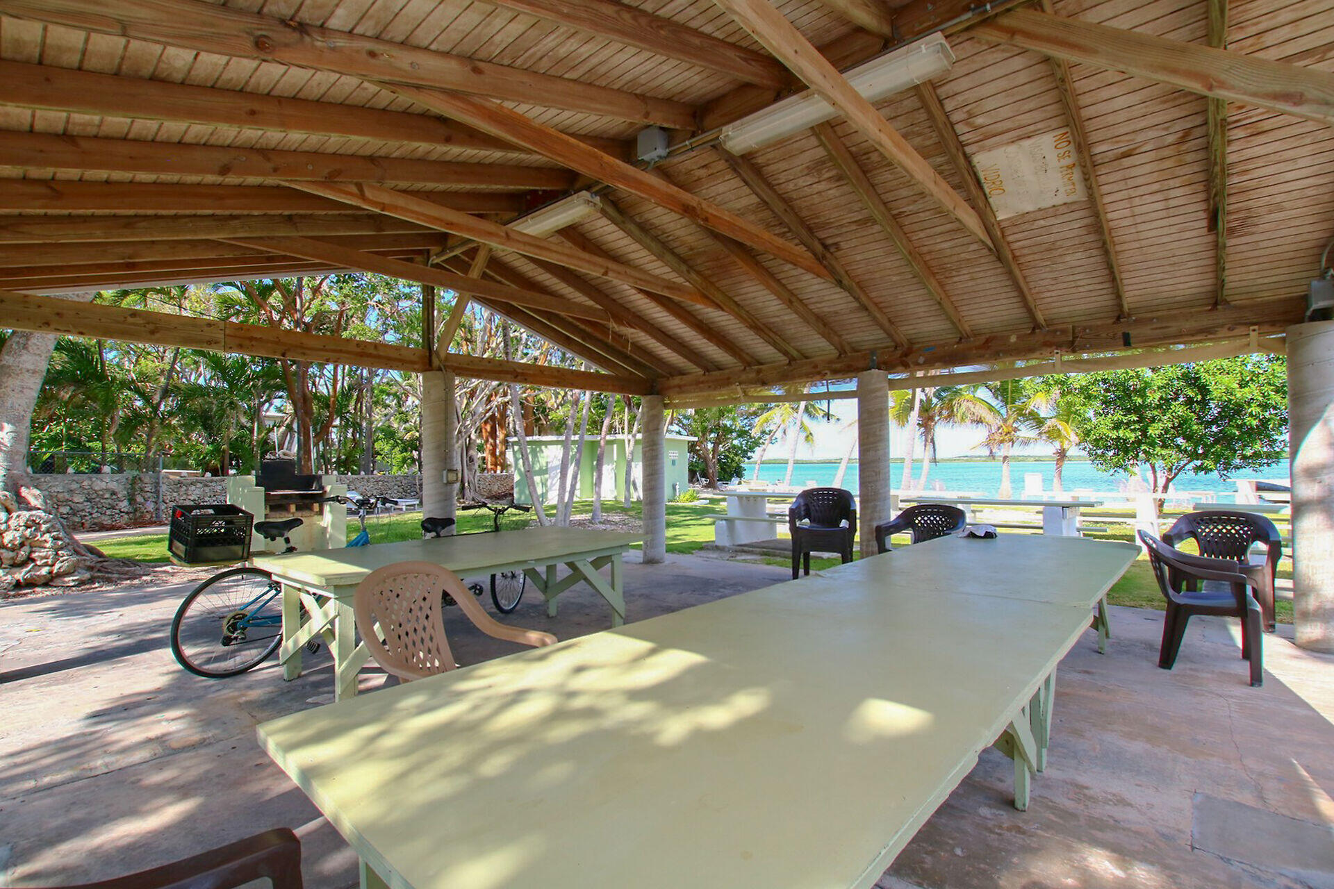 16 Jewfish Avenue Key Largo, FL 33037 - Photo 46 of 69 a view of a patio with table and chairs potted plants and large tree