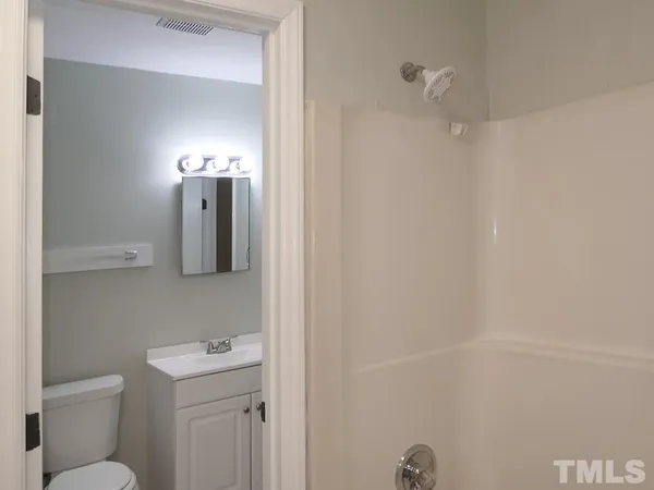 a bathroom with a toilet a sink a shower and mirror