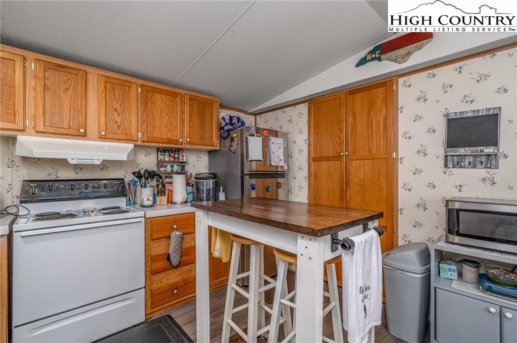 1310 Meat Camp Road Boone, NC 28607 - Photo 21 of 32 a kitchen with stainless steel appliances granite countertop a stove a sink and a microwave