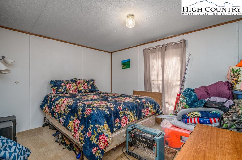 1310 Meat Camp Road Boone, NC 28607 - Photo 29 of 32 a bed sitting in a bedroom next to a window