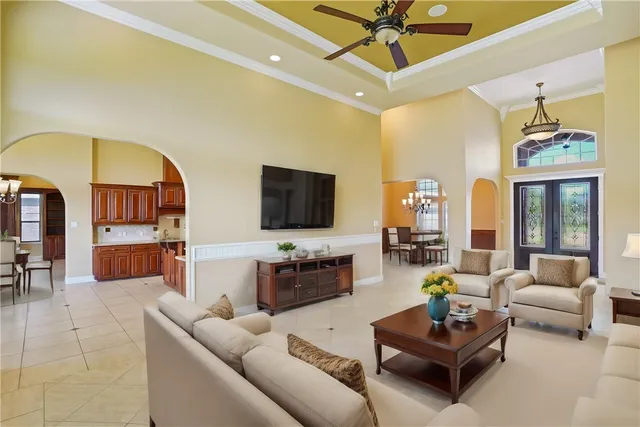 a living room with furniture a flat screen tv and a chandelier