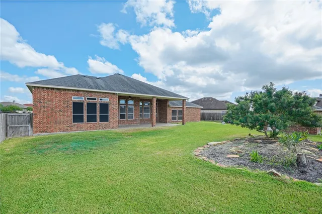 a view of a house with a big yard and a large tree