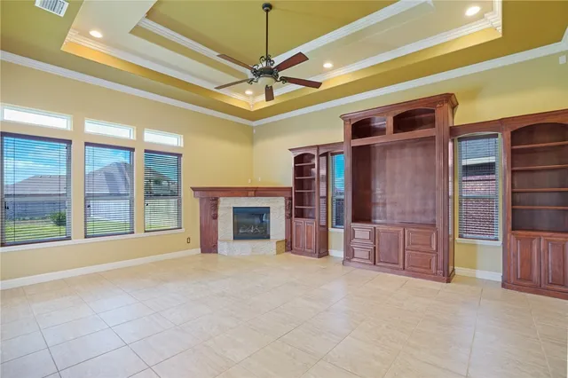 a view of an empty room with a fireplace and a chandelier