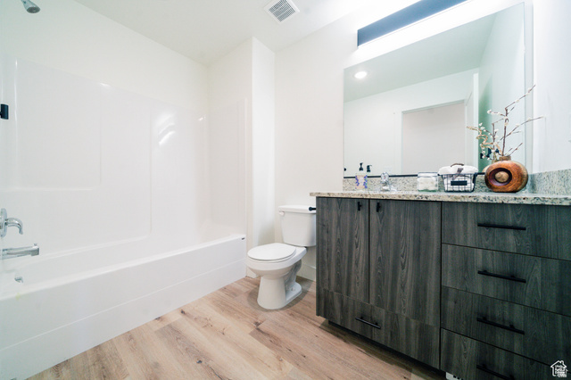 220 Spring Creek Parkway Providence, UT 84332 - Photo 7 of 17 Bathroom featuring a wood-finish vanity with granite countertop, integrated sink, and large wall-mounted mirror