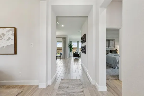 a view of a hallway with a livingroom and a bathroom with sink