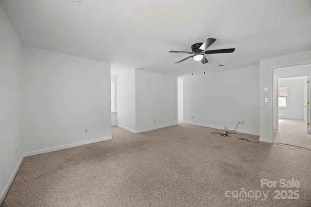 an empty room with a ceiling fan and a window
