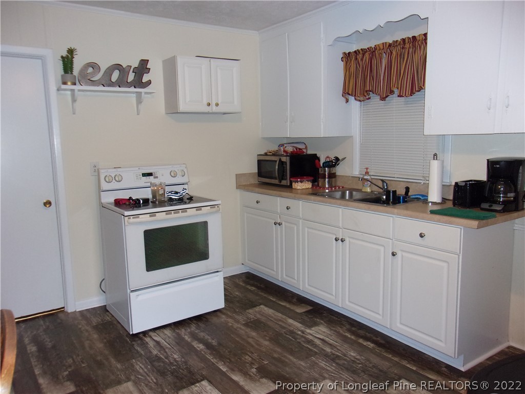 170 Wade-Stedman Road Stedman, NC 28391 - Photo 7 of 12 a kitchen with white cabinets and white appliances