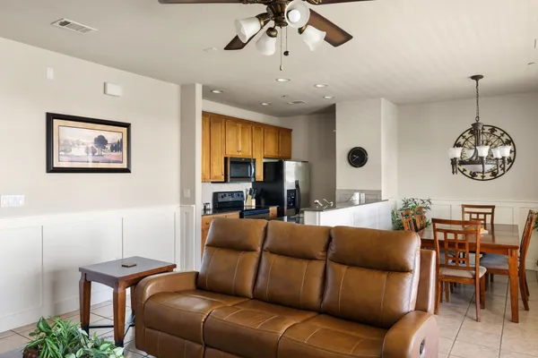 a living room with furniture kitchen view and a chandelier
