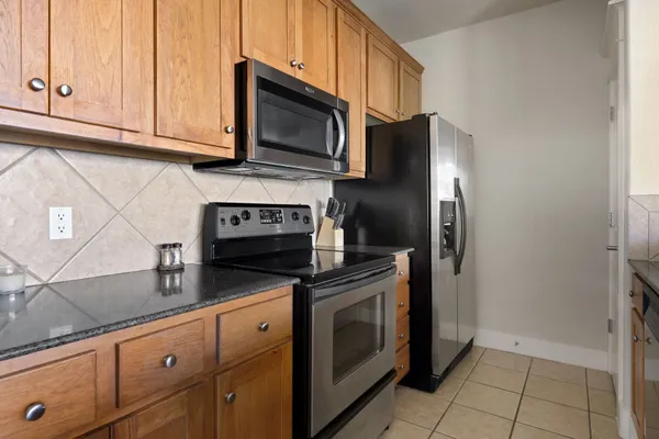 a kitchen with stainless steel appliances granite countertop a refrigerator stove and microwave