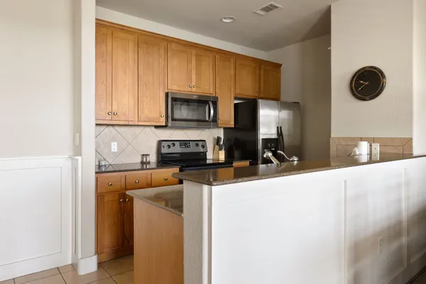 a kitchen with stainless steel appliances granite countertop a refrigerator a stove top oven a sink and dishwasher