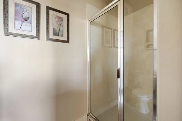 a bathroom with a painting on the wall and shower