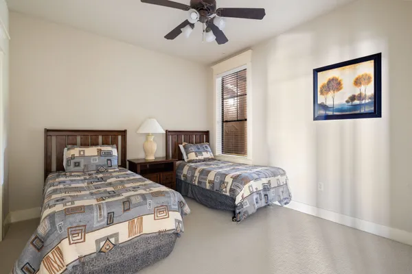 a bedroom with two beds and painting on the wall