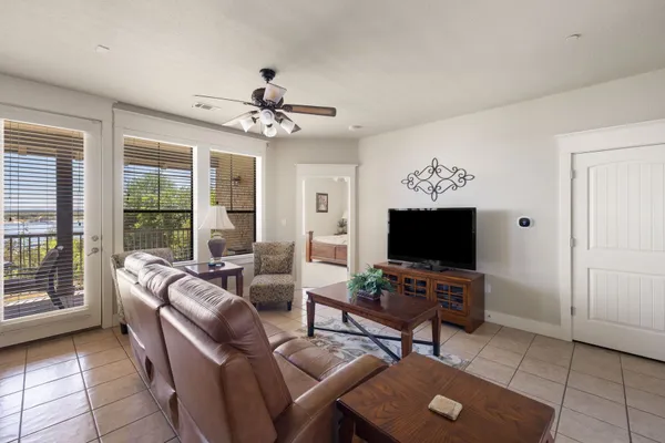 a living room with furniture a flat screen tv and large window