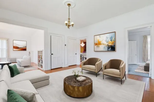 a living room with furniture and a painting on the wall