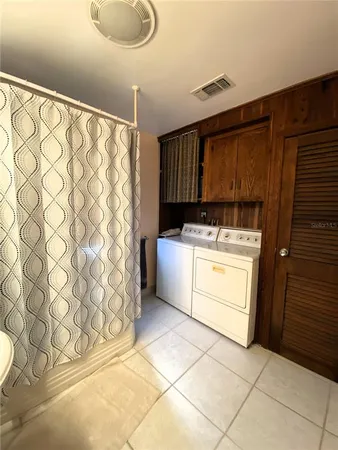 a utility room with cabinets washer and dryer