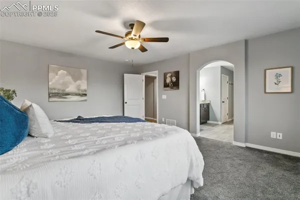 a spacious bedroom with a bed and a chandelier