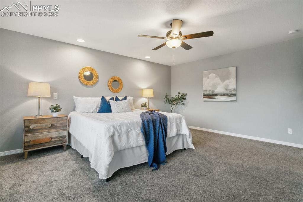 9632 Emerald Vista Drive Peyton, CO 80831 - Photo 22 of 45 a bedroom with a bed and a chandelier