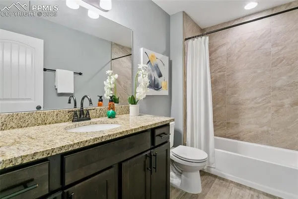 a bathroom with a granite countertop sink toilet and shower