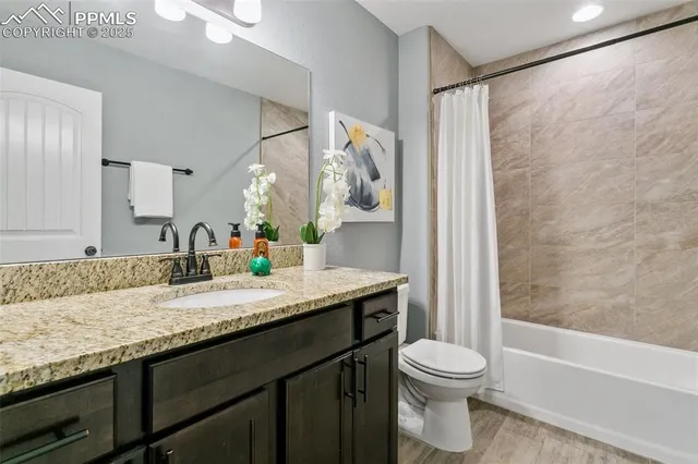 a bathroom with a granite countertop sink toilet and shower