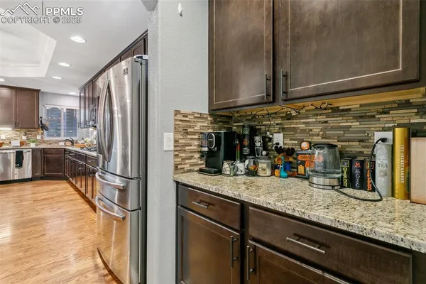 a kitchen with stainless steel appliances granite countertop a refrigerator and a sink