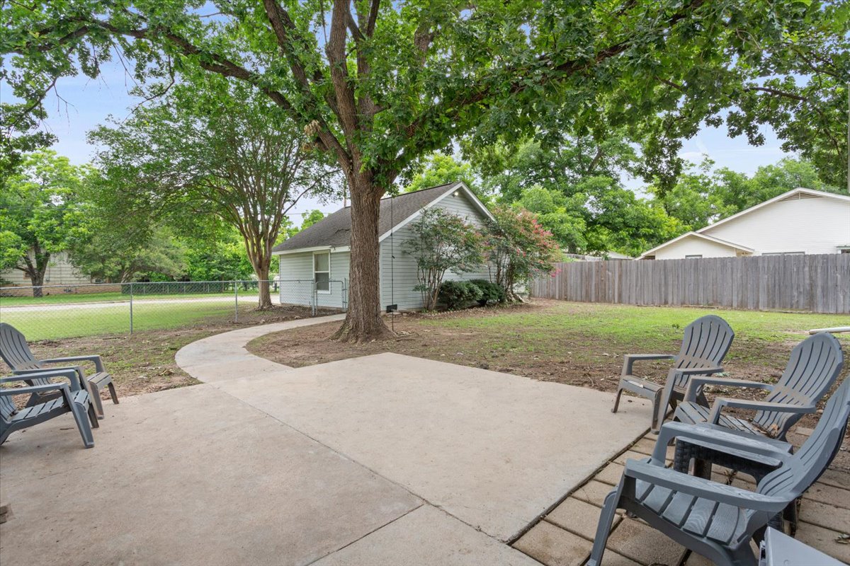 1607 North Harding Avenue Cameron, TX 76520 - Photo 31 of 37 A verdant backyard retreat featuring a concrete patio, winding path, and mature shade trees.