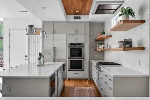 a kitchen with stainless steel appliances a stove a sink and a refrigerator