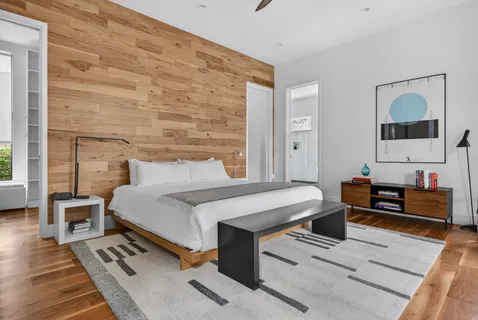 a bedroom with a bed wooden floor and window