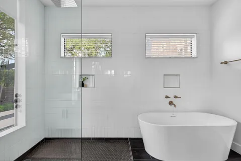 a white bath tub sitting next to a window