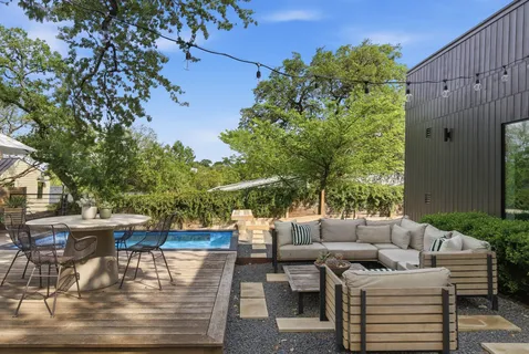 a view of a patio with couches table and chairs and potted plants