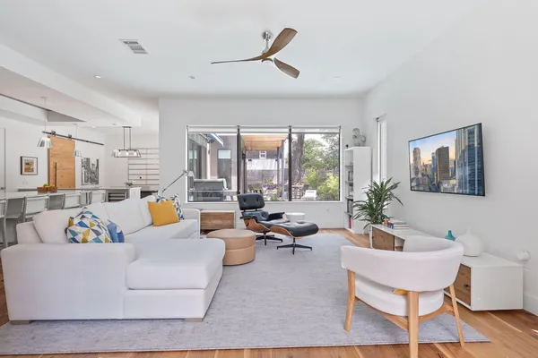 a living room with furniture fireplace and large windows