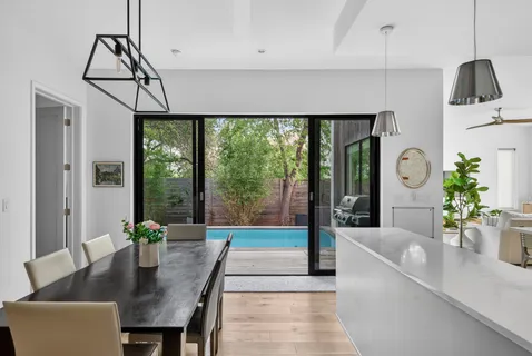 a living room with furniture a dining table and a potted plant