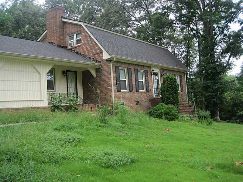 a view of a house with brick walls and a yard with plants