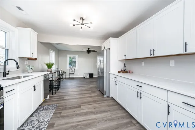 a kitchen with white cabinets and refrigerator