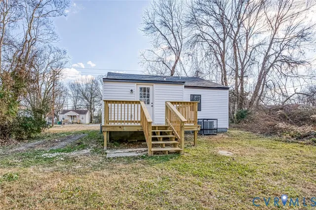 a view of backyard with wooden fence and large trees