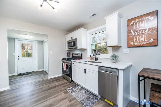 a kitchen with stainless steel appliances granite countertop a stove a sink and a microwave