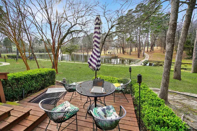 a view of a patio with table and chairs potted plants and a large tree